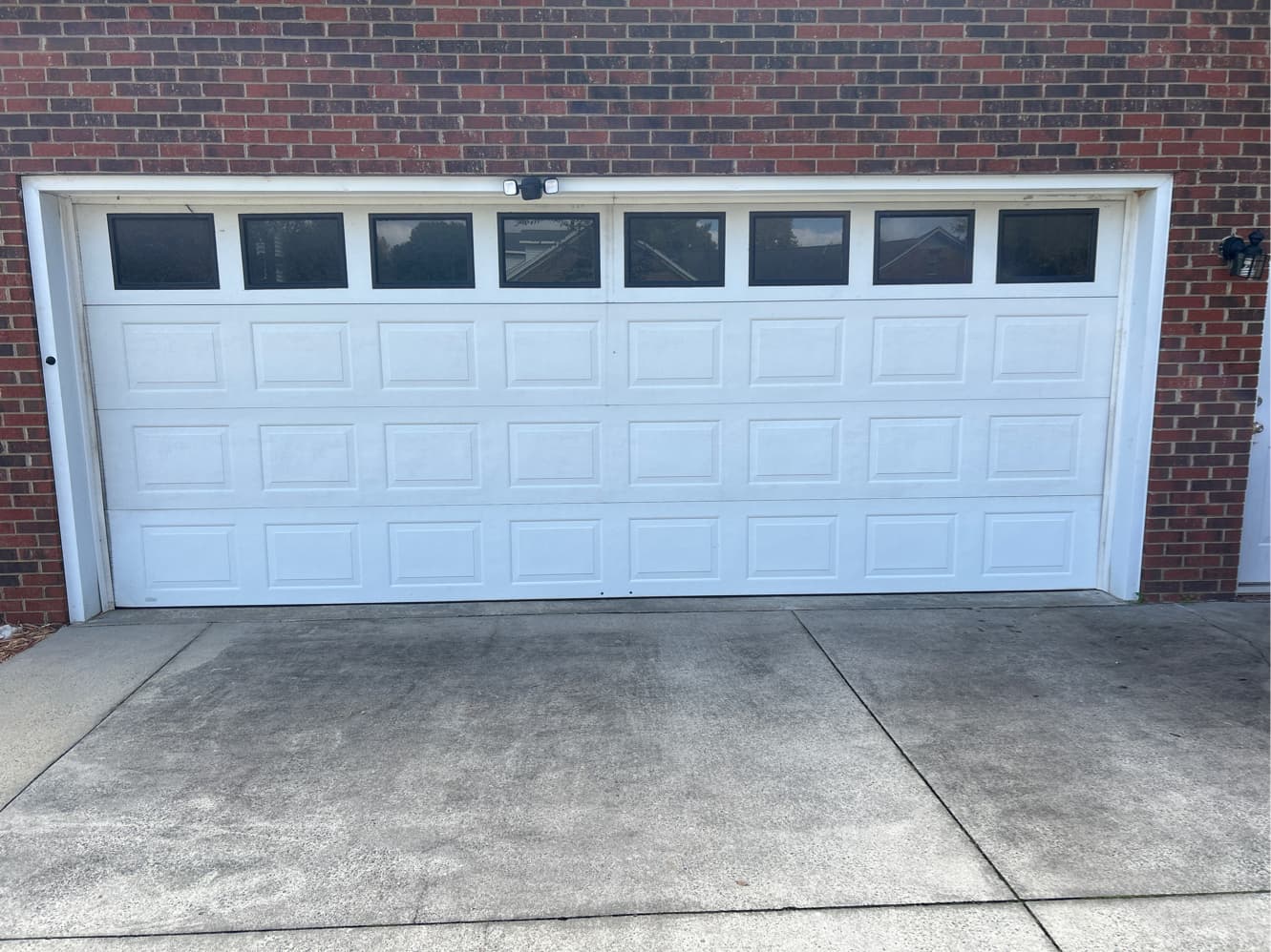 Garage door with worn rollers before service in Greensboro NC