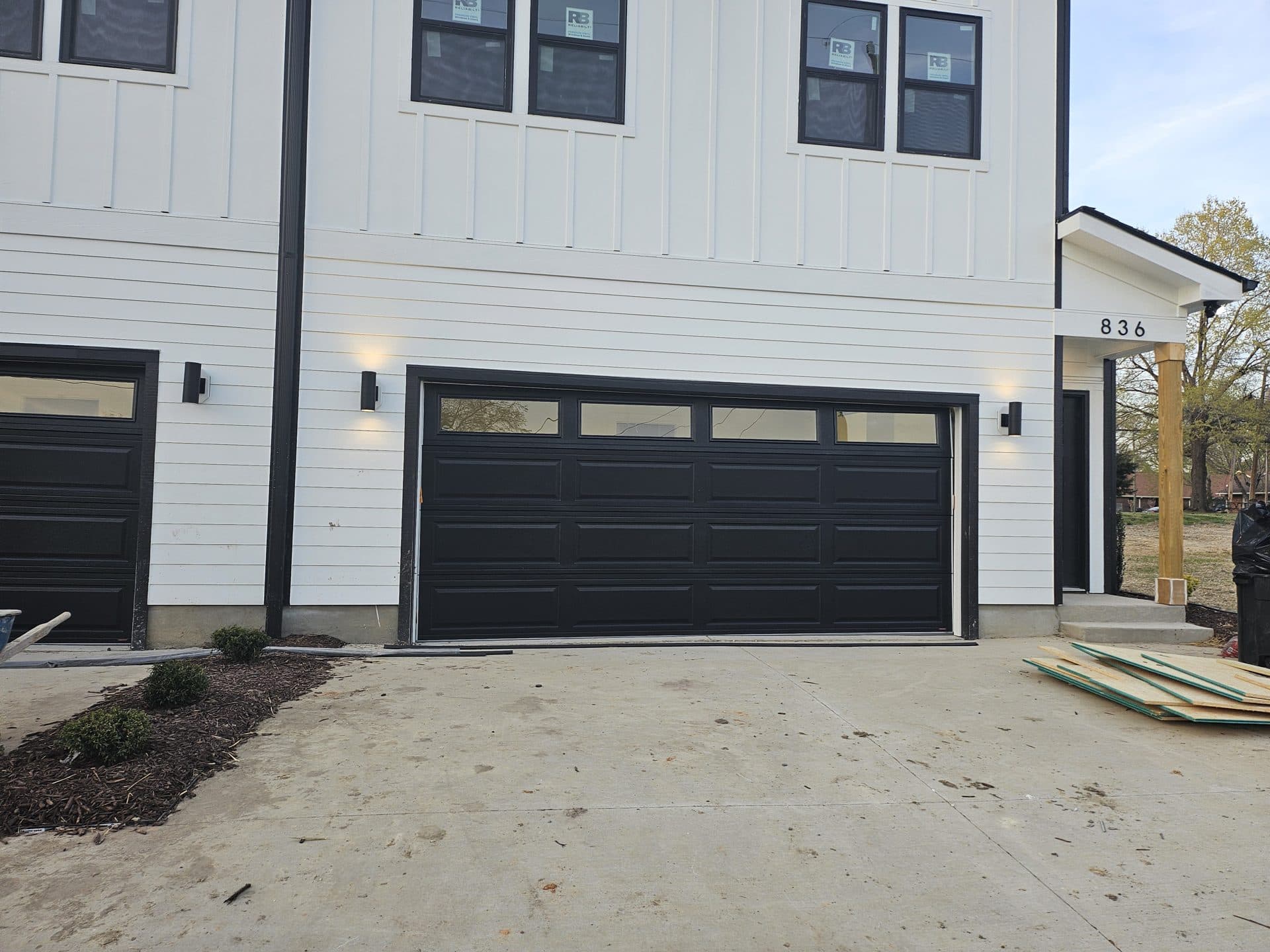 Completed black garage door with transom windows on Day Ave new construction in Burlington NC