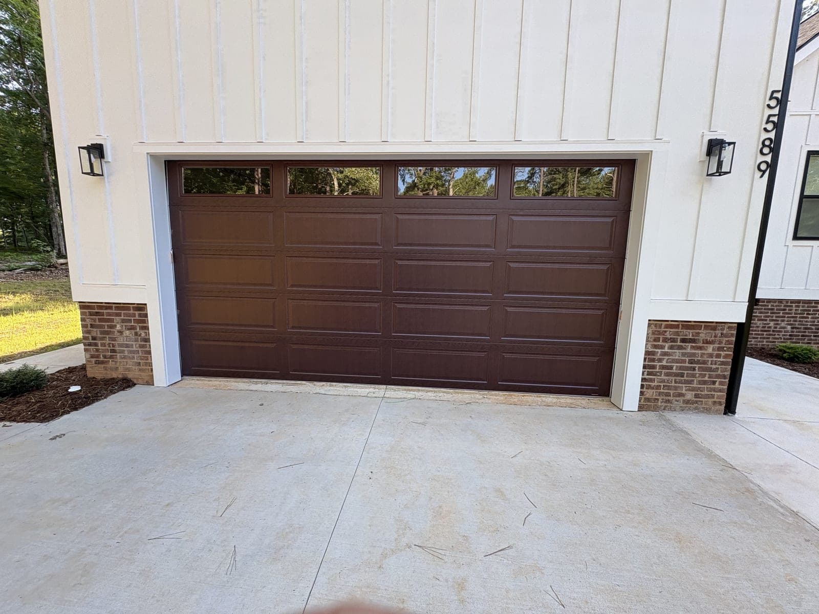 Completed walnut woodgrain raised-panel door with transom windows on new construction farmhouse in Oxford NC